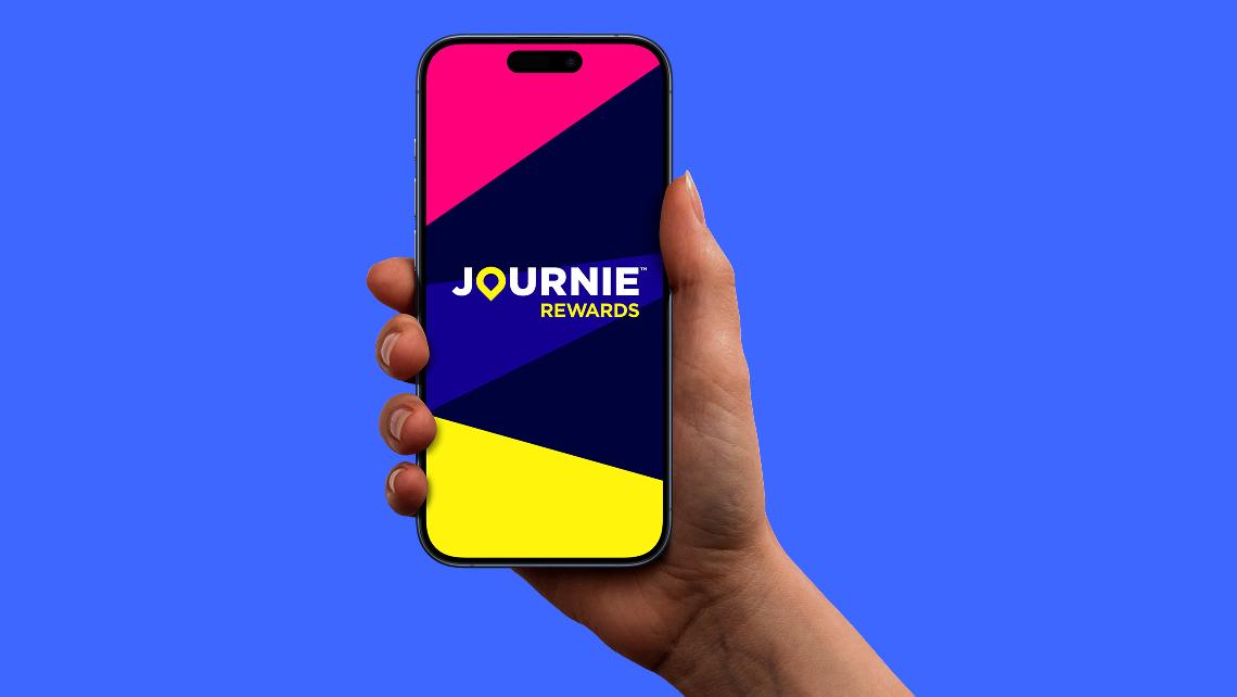Hand holding a phone with the Journie App.