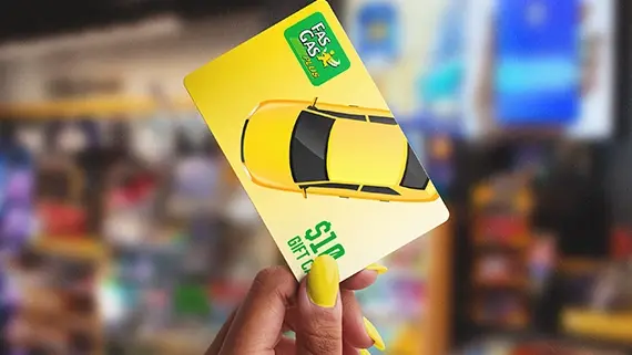 Hand holding a Fas Gas gift card.